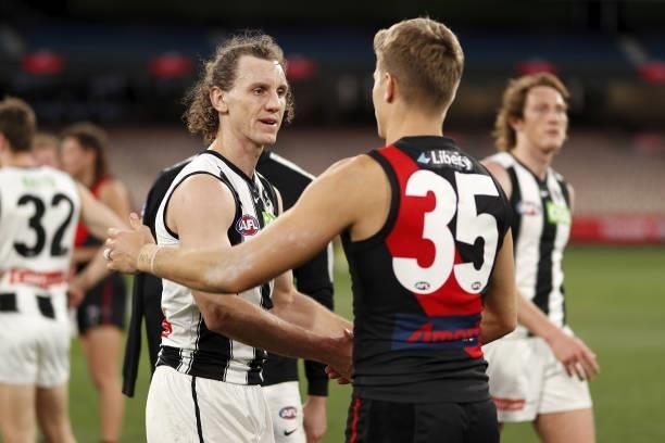 Chris Mayne of the Magpies shakes hands with Matt Guelfi of the Bombers during the 2021 AFL Round 23 match between the Essendon Bombers and the...