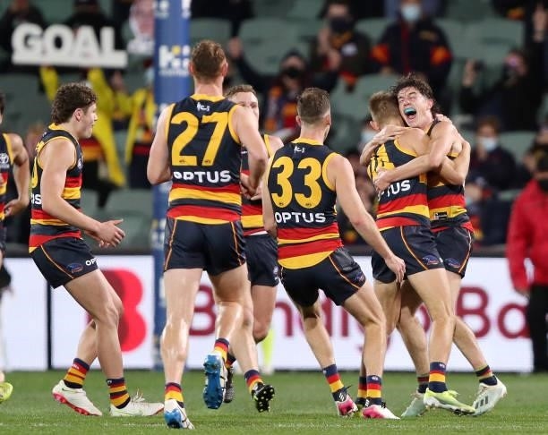 Crows players, including Ned McHenry hung and mob David Mackay of the Crows after kicking a goal in his last game during the 2021 AFL Round 23 match...