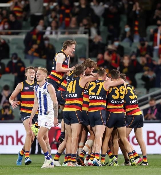 Crows players mobs David Mackay of the Crows after kicking a goal in his last game during the 2021 AFL Round 23 match between the Adelaide Crows and...