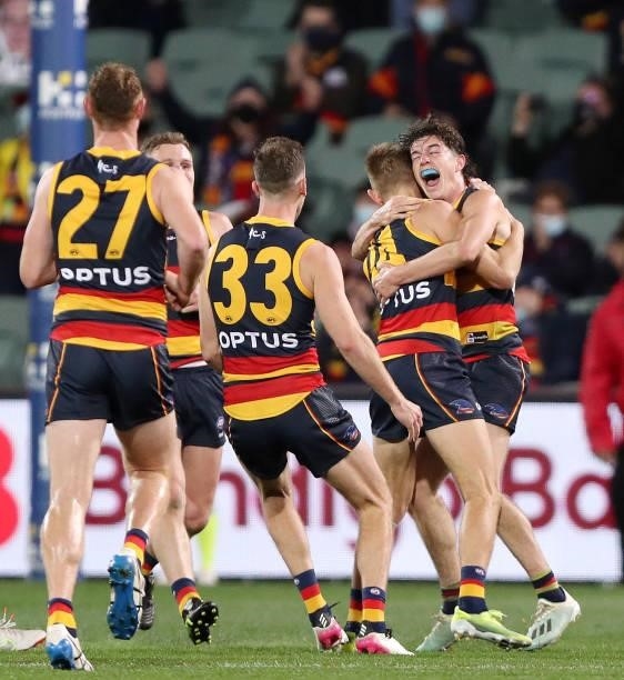 Crows players, including Ned McHenry hung and mob David Mackay of the Crows after kicking a goal in his last game during the 2021 AFL Round 23 match...
