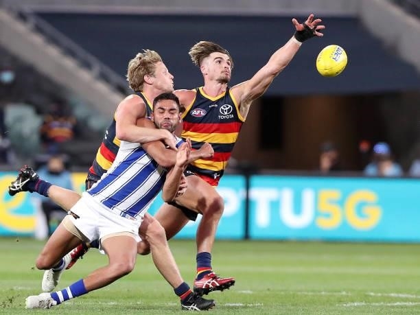 Tarryn Thomas of the Kangaroos under pressure from Rory Sloane of the Crows and Ben Keays during the 2021 AFL Round 23 match between the Adelaide...