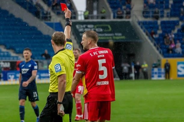 Referee Sascha Stegemann and Marvin Friedrich of 1.FC Union Berlin schows the yellow red card during the Bundesliga match between TSG Hoffenheim and...