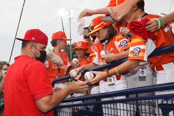 Mike Trout of the Los Angeles Angels signs autographs for young fans before the game between the Los Angeles Angels and the Cleveland Indians at...