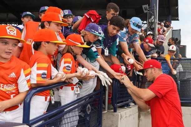 Mike Trout of the Los Angeles Angels signs autographs for young fans before the game between the Los Angeles Angels and the Cleveland Indians at...