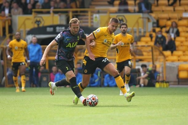 Harry Kane of Tottenham Hotspur races on to the ball ahead of Leander Dendoncker of Wolverhampton Wanderers during the Premier League match between...
