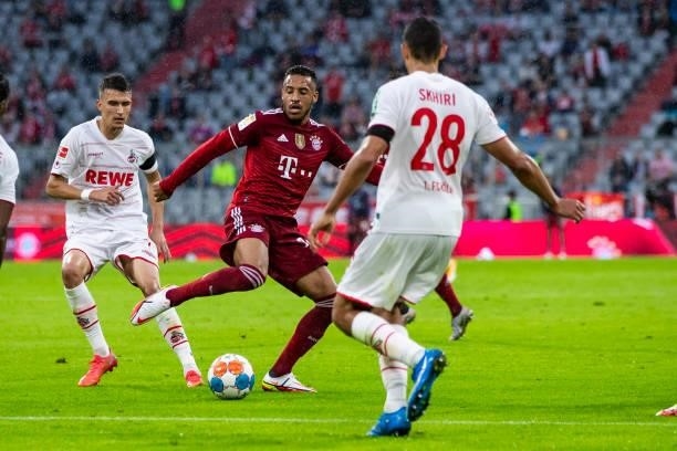 Dejan Ljubicic of 1. FC Koeln, Corentin Tolisso of Bayern Muenchen and Ellyes Skhiri of 1. FC Koeln battle for the ball during the Bundesliga match...