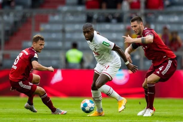 Joshua Kimmich of Bayern Muenchen, Anthony Modeste of 1. FC Koeln and Niklas Suele of Bayern Muenchen battle for the ball during the Bundesliga match...