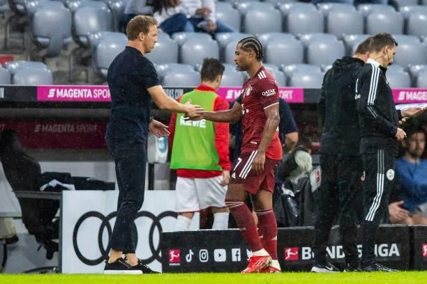 Head coach Julian Nagelsmann of Bayern Muenchen and Serge Gnabry of Bayern Muenchen at the time of substitution during the Bundesliga match between...