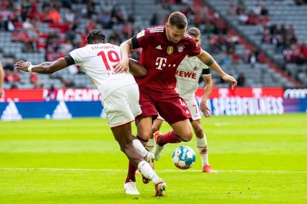Kingsley Ehizibue of 1. FC Koeln and Niklas Suele of Bayern Muenchen battle for the ball during the Bundesliga match between FC Bayern Muenchen and...