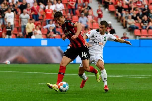 Patrik Schick of Bayer 04 Leverkusen and Stefan Lainer of Borussia Moenchengladbach battle for the ball during the Bundesliga match between Bayer 04...