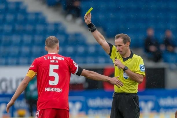 Referee Sascha Stegemann shows Marvin Friedrich of 1.FC Union Berlin und the yellow card during the Bundesliga match between TSG Hoffenheim and 1. FC...