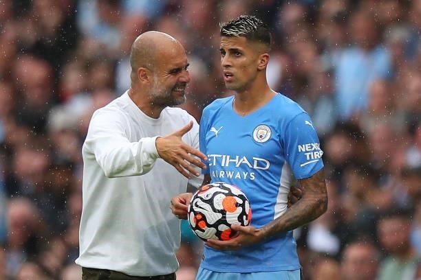 Pep Guardiola the head coach / manager of Manchester City and Joao Cancelo of Manchester City during the Premier League match between Manchester City...