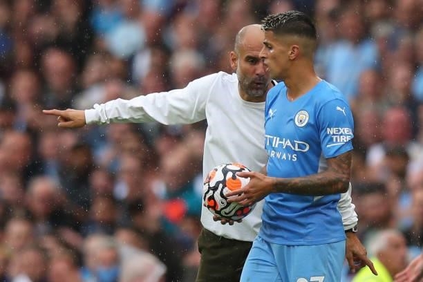 Pep Guardiola the head coach / manager of Manchester City and Joao Cancelo of Manchester City during the Premier League match between Manchester City...