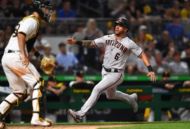 David Peralta of the Arizona Diamondbacks scores in front of Jacob Stallings of the Pittsburgh Pirates during the fifth inning at PNC Park on August...