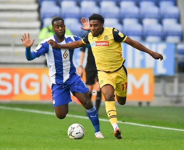 Bolton Wanderers' Oladapo Afolayan battles with Wigan Athletic's Gavin Massey during the Carabao Cup Second Round match between Wigan Athletic and...