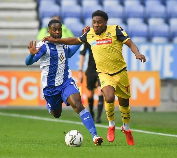 Bolton Wanderers' Oladapo Afolayan battles with Wigan Athletic's Gavin Massey during the Carabao Cup Second Round match between Wigan Athletic and...