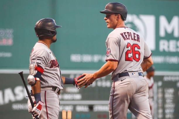 Max Kepler high fives Luis Arraez of the Minnesota Twins after scoring in the first inning of a game against the Boston Red Sox at Fenway Park on...