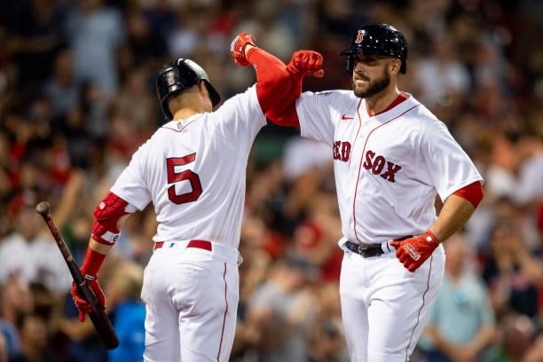Travis Shaw of the Boston Red Sox reacts with Enrique Hernandez after hitting a solo home run during the third inning of a game against the Minnesota...