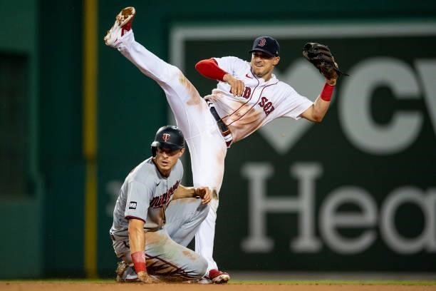 Enrique Hernandez of the Boston Red Sox lifts his leg as he attempts to turn a double play during the sixth inning of a game against the Minnesota...