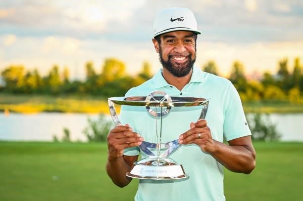Tony Finau smiles with the tournament trophy following his playoff victory during the final round of THE NORTHERN TRUST, the first event of the...