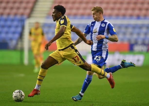 Bolton Wanderers' Oladapo Afolayan battles with Wigan Athletic's James McClean during the Carabao Cup Second Round match between Wigan Athletic and...