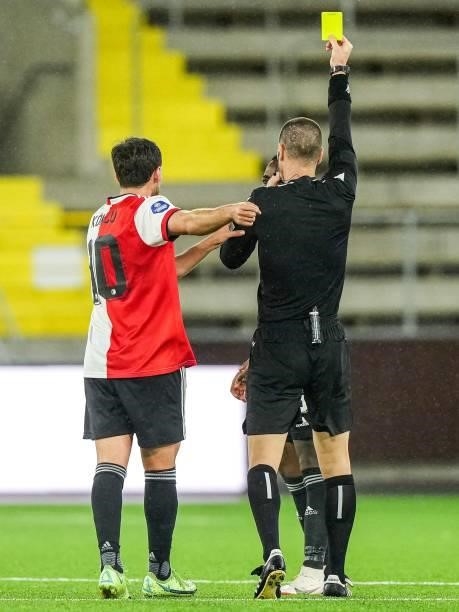 Referee Georgi Kabakov gives Ridgeciano Haps of Feyenoord a yellow card during the UEFA Conference League play-offs match between IF Elfsborg and...