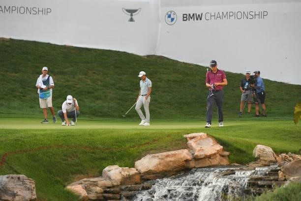 Justin Thomas, Collin Morikawa and Patrick Cantlay play the 18th green during the first round of the BMW Championship at Caves Valley Golf Club on...