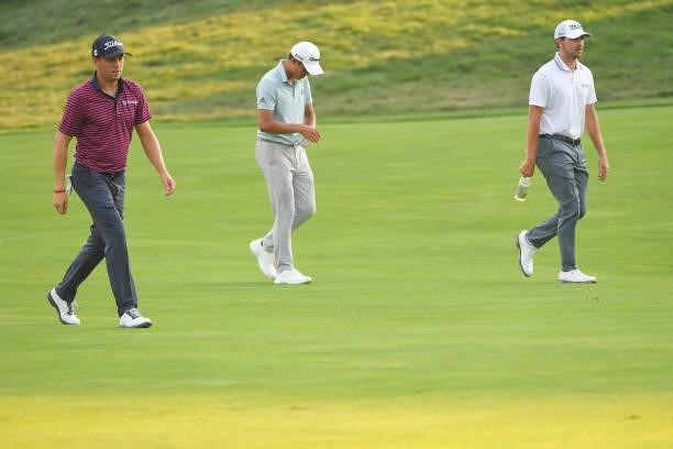 Justin Thomas, Collin Morikawa and Patrick Cantlay walk along the 18th fairway during the first round of the BMW Championship at Caves Valley Golf...