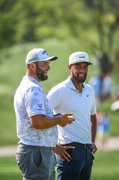 Tony Finau and Jon Rahm of Spain smile after they both made birdie putts on the 17th hole green during the first round of the BMW Championship, the...
