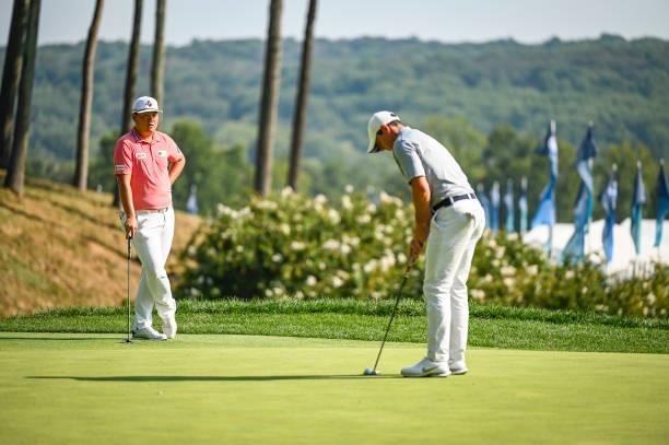 Sungjae Im of South Korea watches as Rory McIlroy of Northern Ireland putts on the ninth hole green during the first round of the BMW Championship,...