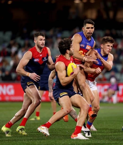 Christian Petracca of the Demons classes with Charlie Cameron of the Lions during the 2021 AFL First Qualifying Final match between the Melbourne...