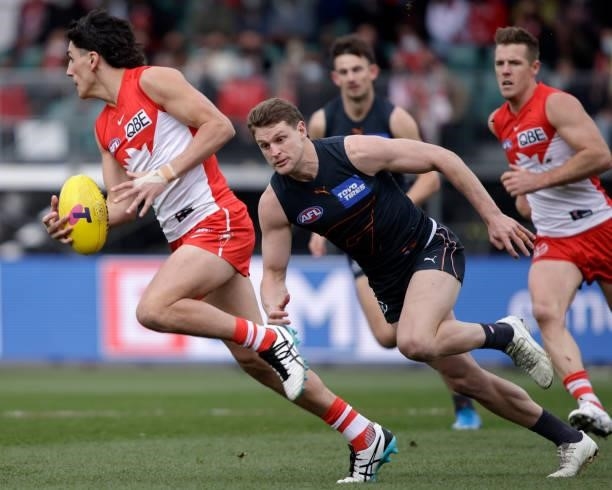 Justin McInerney of the Swans is chased by Jacob Hopper of the Giants during the 2021 AFL Second Elimination Final match between the Sydney Swans and...