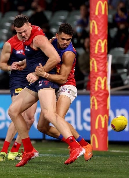 Steven May of the Demons is tackled by Charlie Cameron of the Lions during the 2021 AFL First Qualifying Final match between the Melbourne Demons and...