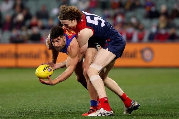 Marcus Adams of the Lions is tackled by Ben Brown of the Demons during the 2021 AFL First Qualifying Final match between the Melbourne Demons and the...