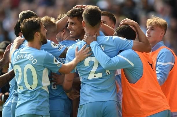 Manchester City's Spanish midfielder Rodrigo celebrates with teammates after scoring his team's fourth goal during the English Premier League...