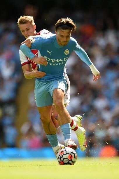 Arsenal's Norwegian midfielder Martin Odegaard vies with Manchester City's English midfielder Jack Grealish during the English Premier League...