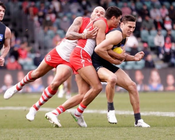 Isaac Cumming of the Giants is tackled by Lance Franklin of the Swans and James Bell of the Swans during the 2021 AFL Second Elimination Final match...