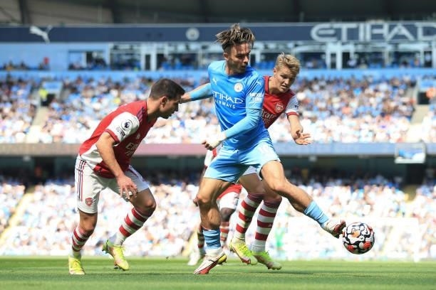 Jack Grealish of Manchester City battles with Cedric Soares of Arsenal and Martin Odegaard of Arsenal during the Premier League match between...