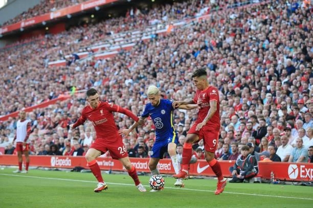 Jorginho of Chelsea battles with Andrew Robertson of Liverpool and Roberto Firmino of Liverpool during the Premier League match between Liverpool and...