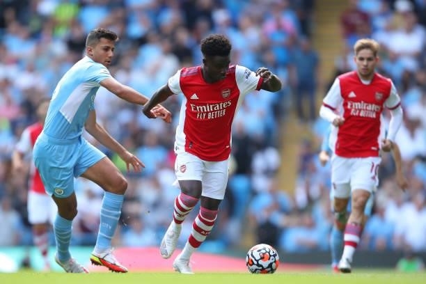 Rodri of Manchester City and Bukayo Saka of Arsenal during the Premier League match between Manchester City and Arsenal at Etihad Stadium on August...