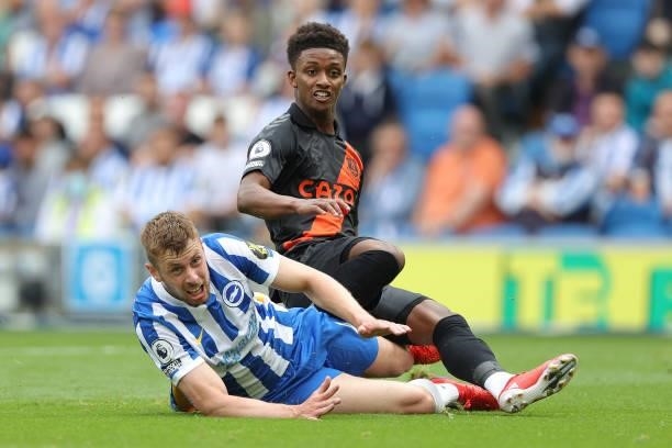 Demarai Gray of Everton lands on Adam Webster of Brighton after scoring during the Premier League match between Brighton & Hove Albion and Everton at...