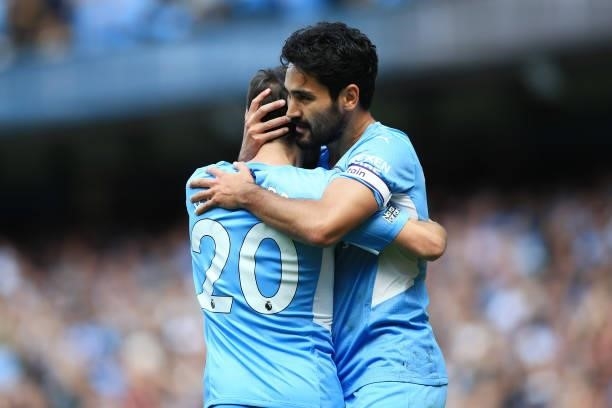 Ilkay Gundogan of Manchester City hugs teammate Bernardo Silva of Manchester City during the Premier League match between Manchester City and Arsenal...