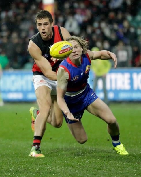Tom Cutler of the Bombers and Cody Weightman compete for the ball during the 2021 AFL First Elimination Final match between the Western Bulldogs and...
