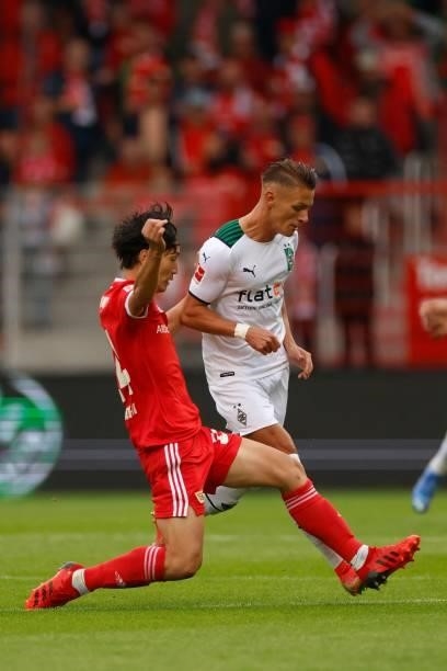 Union Berlin's Japanese midfielder Genki Haraguchi and Moenchengladbach's Austrian midfielder Hannes Wolf vie for the ball during the German first...