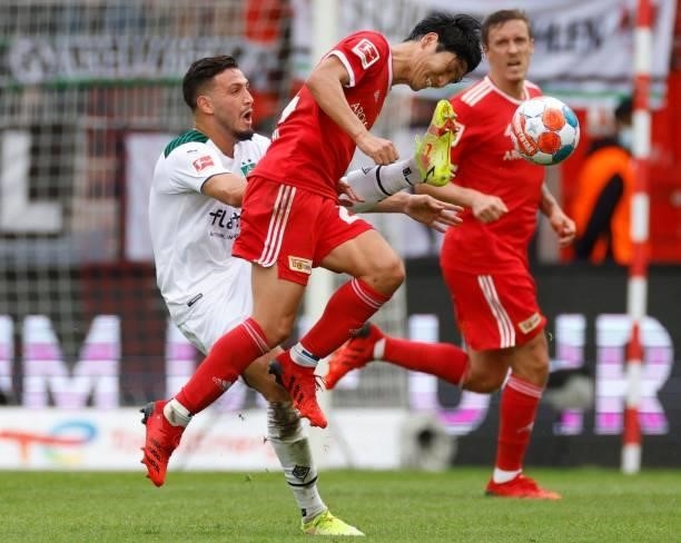 Moenchengladbach's Algerian defender Ramy Bensebaini and Union Berlin's Japanese midfielder Genki Haraguchi vie for the ball during the German first...