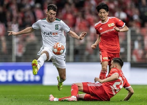 Joe Scally of Borussia Mönchengladbach in action with Genki Haraguchi of 1.FC Union Berlin and Niko Gießelmann of 1.FC Union Berlin during the...