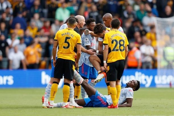 Ruben Neves of Wolverhampton Wanderers shows Mike Dean his ankle after a challenge from Paul Pogba of Manchester United during the Premier League...