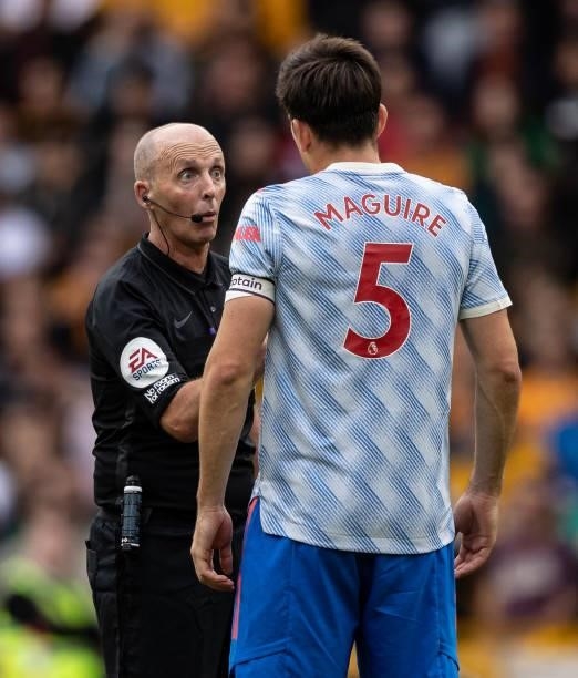 Referee Mike Dean speaks to Manchester United's Harry Maguire during the Premier League match between Wolverhampton Wanderers and Manchester United...