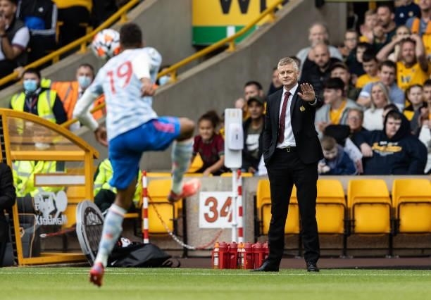 Manchester United's manager Ole Gunnar Solskjaer gestures towards Raphael Varane during the Premier League match between Wolverhampton Wanderers and...