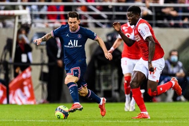 Lionel Messi of Paris Saint Germain is chased by Marshall Munetsi of Reims during his debut for PSG during the Ligue 1 Uber Eats match between Reims...
